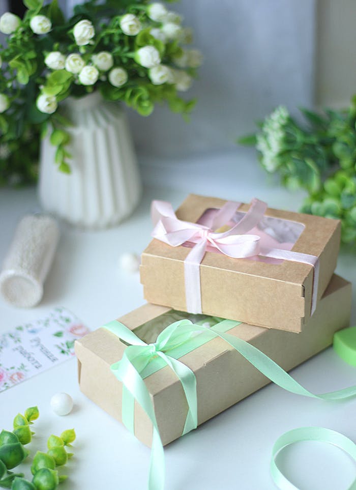 Stylish kraft gift boxes with ribbons, ideal for special occasions. Captured amidst floral decor.